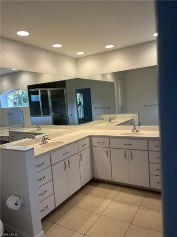 Bathroom with dual bowl vanity and tile flooring