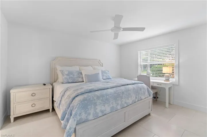 Tiled bedroom featuring ceiling fan