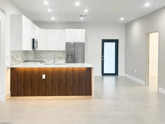 Kitchen featuring a peninsula, light countertops, appliances with stainless steel finishes, backsplash, and recessed lighting