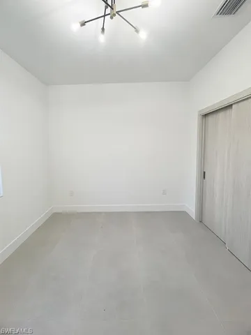 Unfurnished bedroom featuring a closet and a chandelier