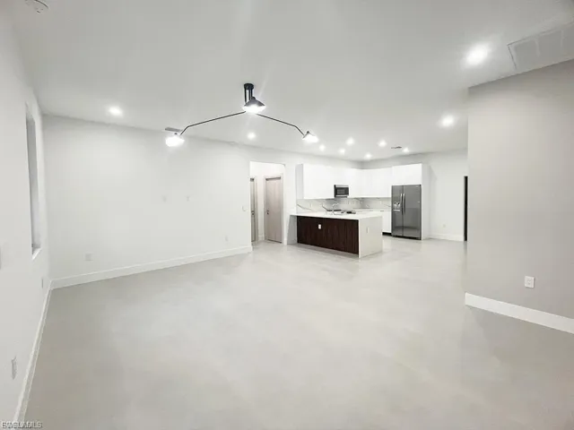 Unfurnished living room featuring finished concrete flooring and recessed lighting