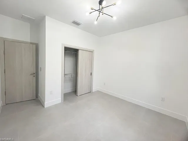 Unfurnished bedroom with a chandelier and a closet