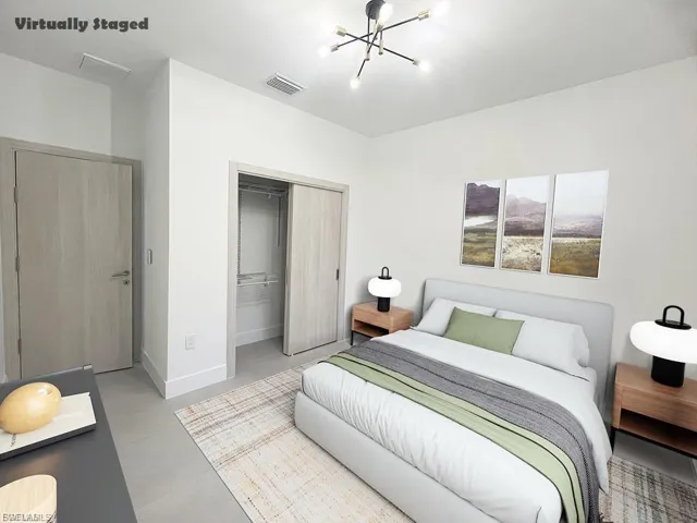 Bedroom with a chandelier, finished concrete flooring, and a closet