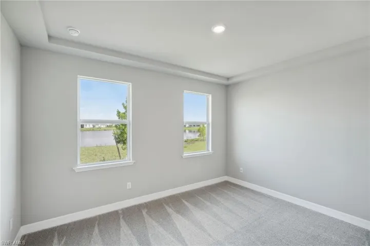 Carpeted spare room with a water view