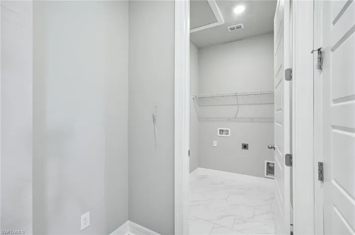 Clothes washing area featuring hookup for a washing machine and electric dryer hookup