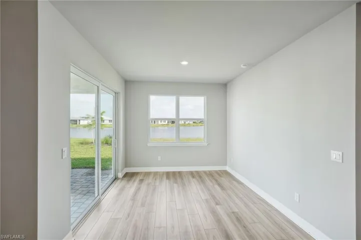 Spare room featuring light wood-type flooring, a healthy amount of sunlight, and a water view