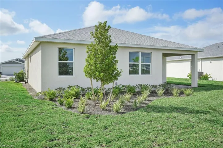 View of side of property with a lawn and a garage