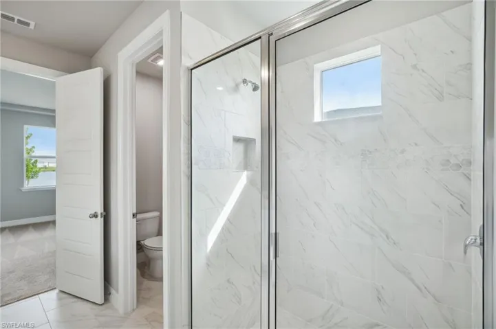 Bathroom with toilet and a shower with shower door