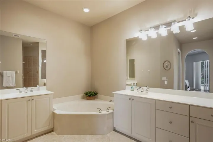 Bathroom with tile patterned flooring, a bathing tub, and vanity