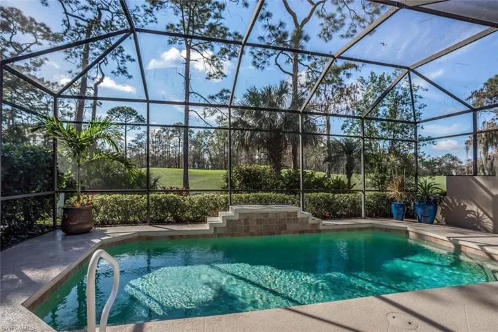 View of pool featuring glass enclosure and a patio area