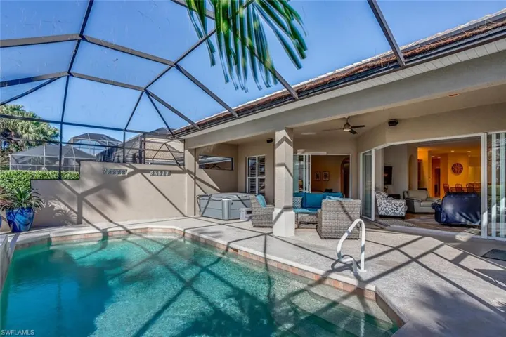 View of swimming pool with ceiling fan, outdoor lounge area, a patio, and a lanai