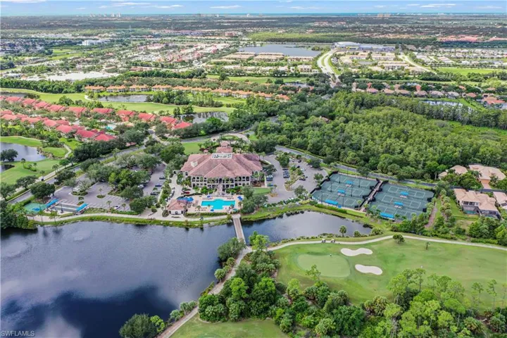 Aerial view of property and surrounding area with a large body of water and a golf course