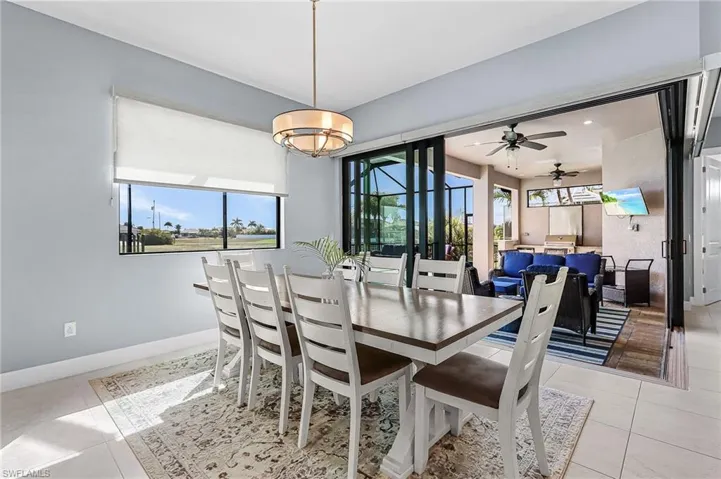 large dining area, open floor plan to kitchen, living room with tented lanai doors that open to lanai