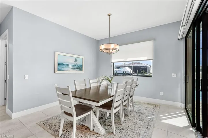 large dining area, open floor plan to kitchen, living room with tented lanai doors that open to lanai