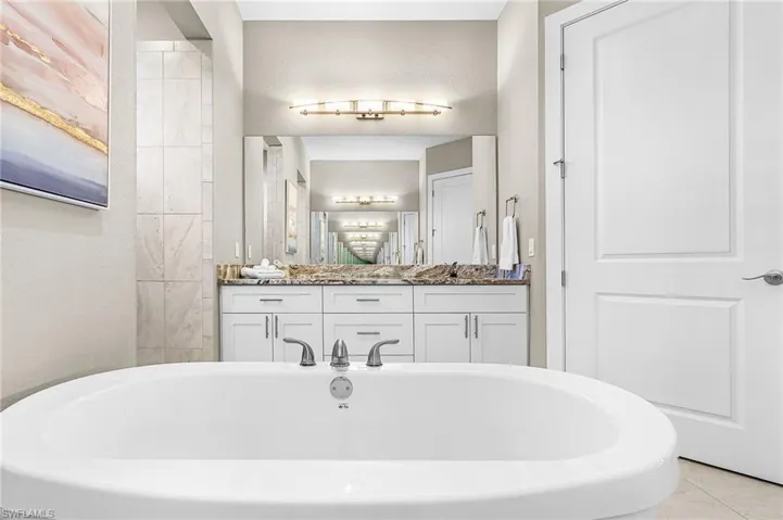 dual vanities, soaking tub, private toilet, large storage closet, large walk-in shower