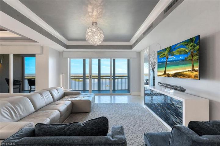 The spacious living room opens to an expansive screened lanai, perfect for entertaining family and friends.