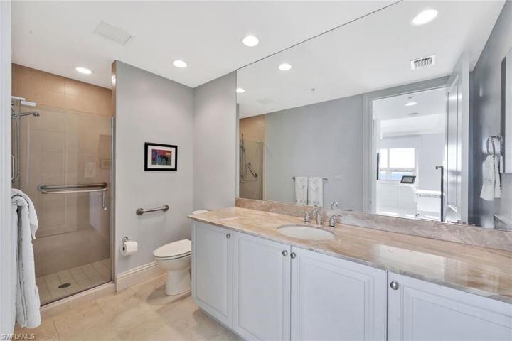 The en-suite bathroom of the 2nd bedroom has a raised vanity and marble countertop.