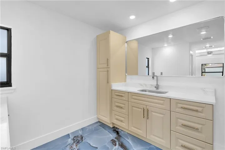 Bathroom featuring dark marble finish floors and vanity