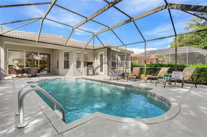 Swimming pool featuring a sunroom, a lanai, a patio area, ceiling fan, and outdoor dining space
