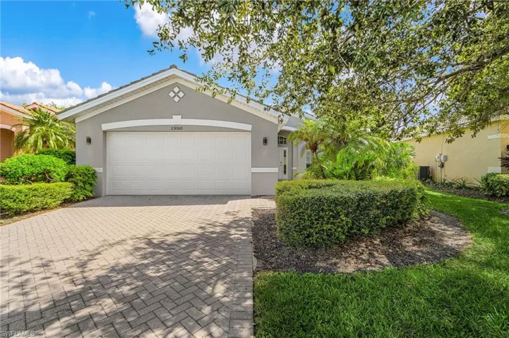 Ranch-style house with decorative driveway, stucco siding, and a garage