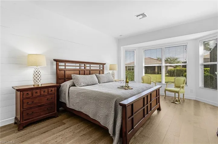 Bedroom with wood finished floors and multiple windows