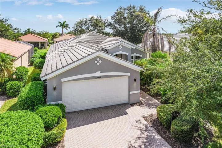 View of front of house with stucco siding, decorative driveway, and an attached garage