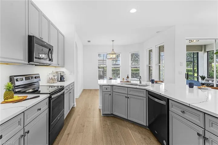 Kitchen with gray cabinets, appliances with stainless steel finishes, light wood-style flooring, recessed lighting, and plenty of natural light