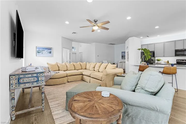 Living room with recessed lighting, light wood-type flooring, and ceiling fan