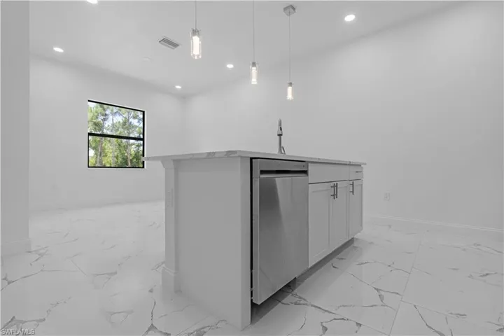 Kitchen with light marble finish flooring, dishwasher, hanging light fixtures, white cabinets, and recessed lighting