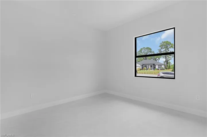 Spare room featuring baseboards and concrete floors
