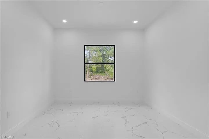 Spare room with light marble finish floors and recessed lighting