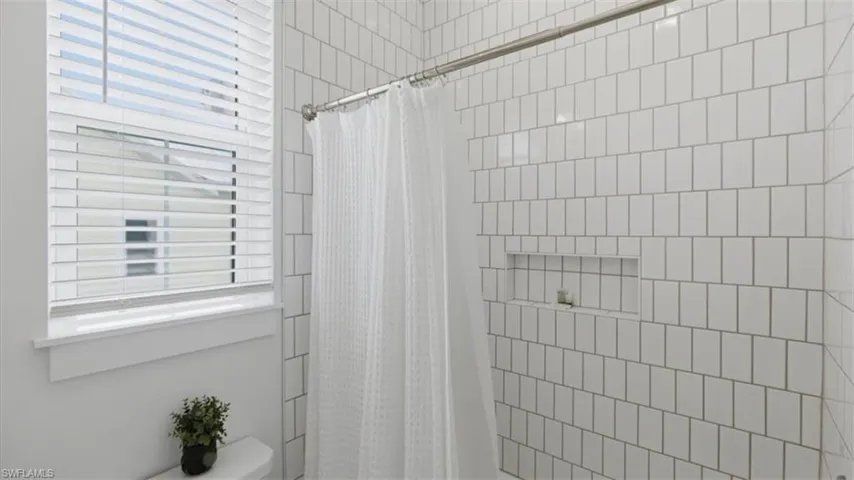 Bathroom featuring a stall shower and toilet - Virtually Edited