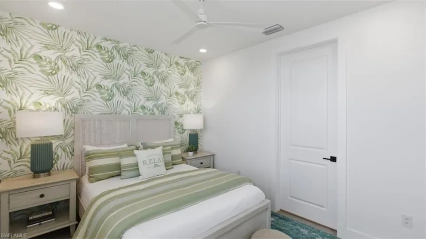Bedroom featuring wallpapered walls, an accent wall, recessed lighting, and ceiling fan - Virtually Edited