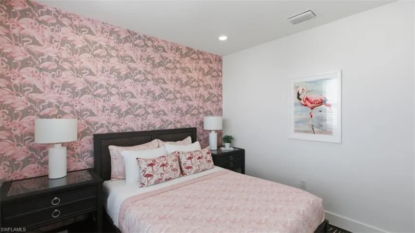 Bedroom featuring wallpapered walls, an accent wall, and recessed lighting - Virtually Edited