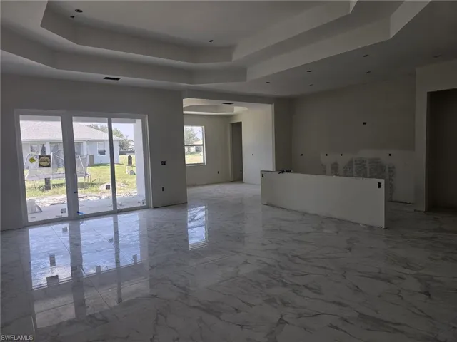 Unfurnished room with tile flooring and a tray ceiling