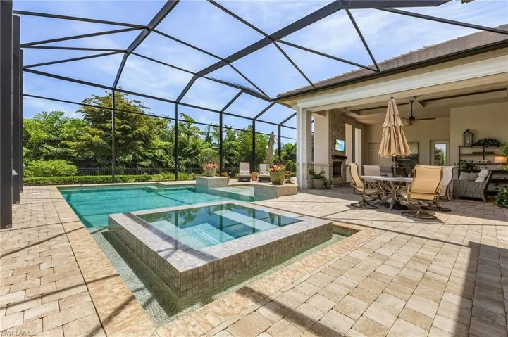 View of pool featuring a patio, a lanai, and an in ground hot tub