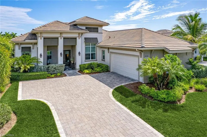 View of front of property with a garage and a front lawn