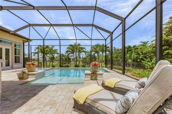 View of pool with glass enclosure and a patio area