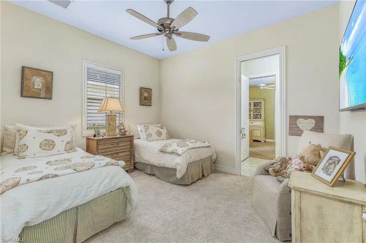 Carpeted bedroom featuring ceiling fan
