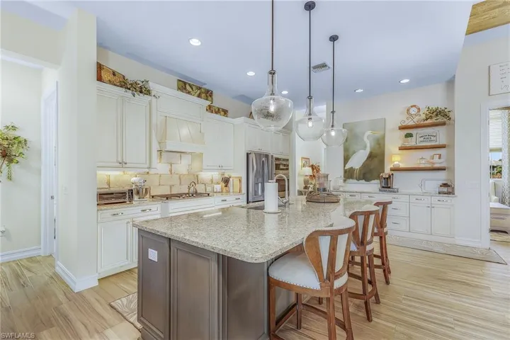 Kitchen with backsplash, white cabinetry, and appliances with stainless steel finishes