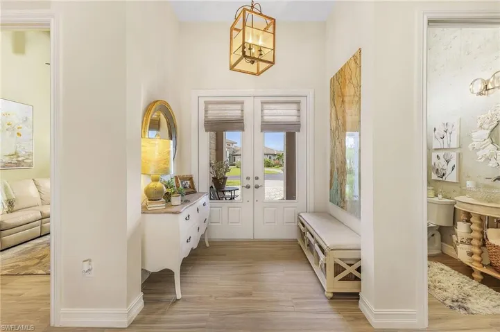 Foyer featuring a chandelier, french doors, and light wood-type flooring