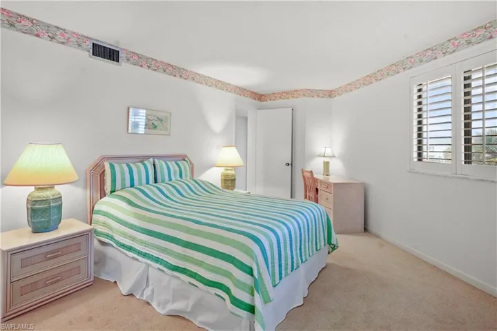 Bedroom with visible vents, baseboards, and carpet