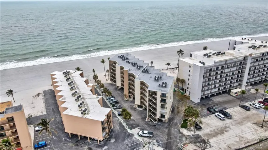 Birds eye view of property with a beach view and a water view