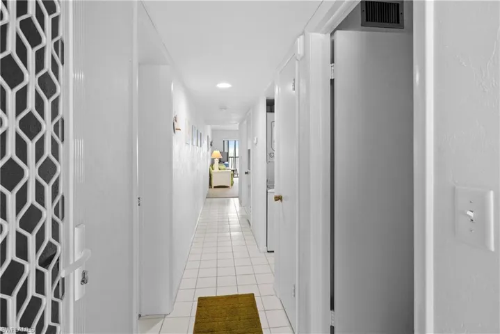 Hallway featuring light tile patterned flooring and visible vents