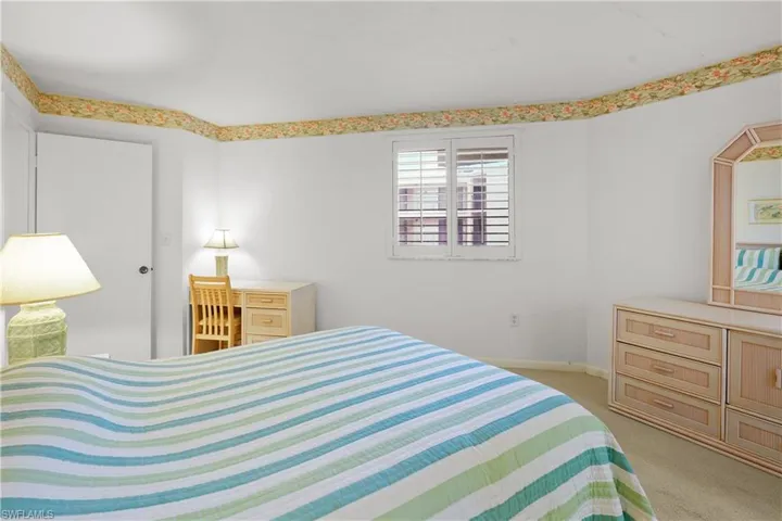 Bedroom with light carpet and baseboards