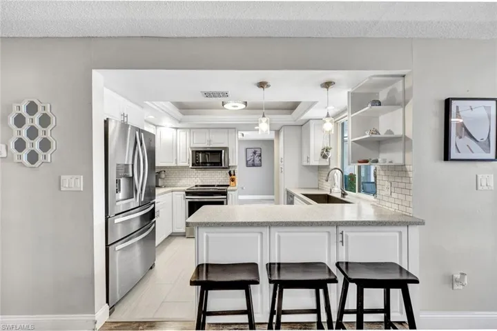 Kitchen updated with Corian counters and stainless appliances.