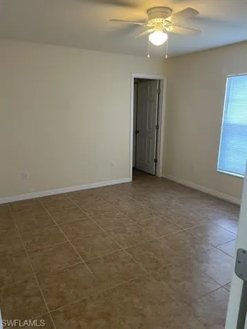 Spare room with baseboards and ceiling fan