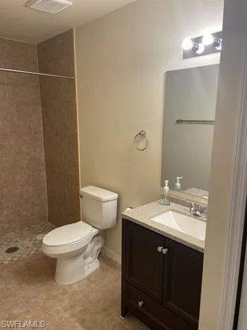 Full bath with vanity, a shower stall, and light tile patterned flooring