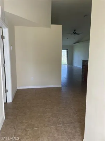 Tiled spare room with baseboards and ceiling fan