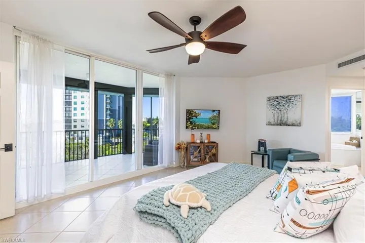 Master Bedroom suite with tile floors & ceiling fan, lanai access, and attached bath
